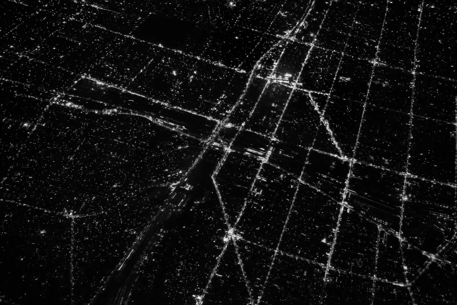 Aerial night view of a city grid, points of light like signals